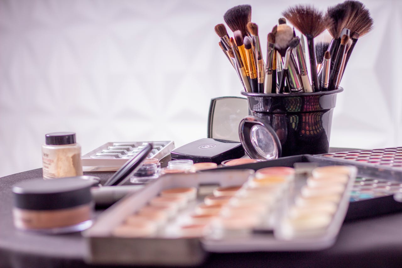 services-02 Close-up of a professional makeup brush set and cosmetics on a table for beauty use.