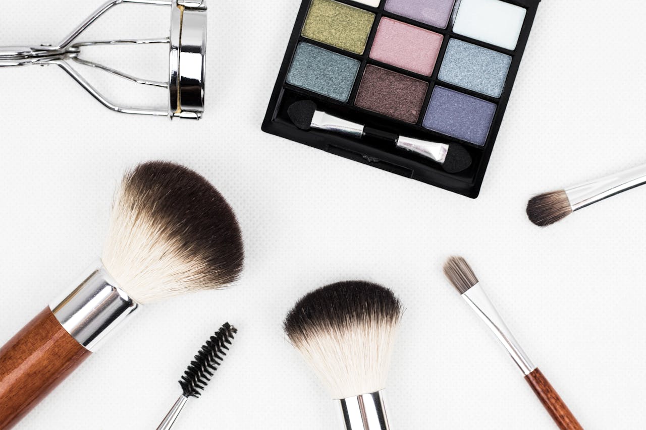 services-03 Top view of makeup tools and a colorful eyeshadow palette arranged artistically.