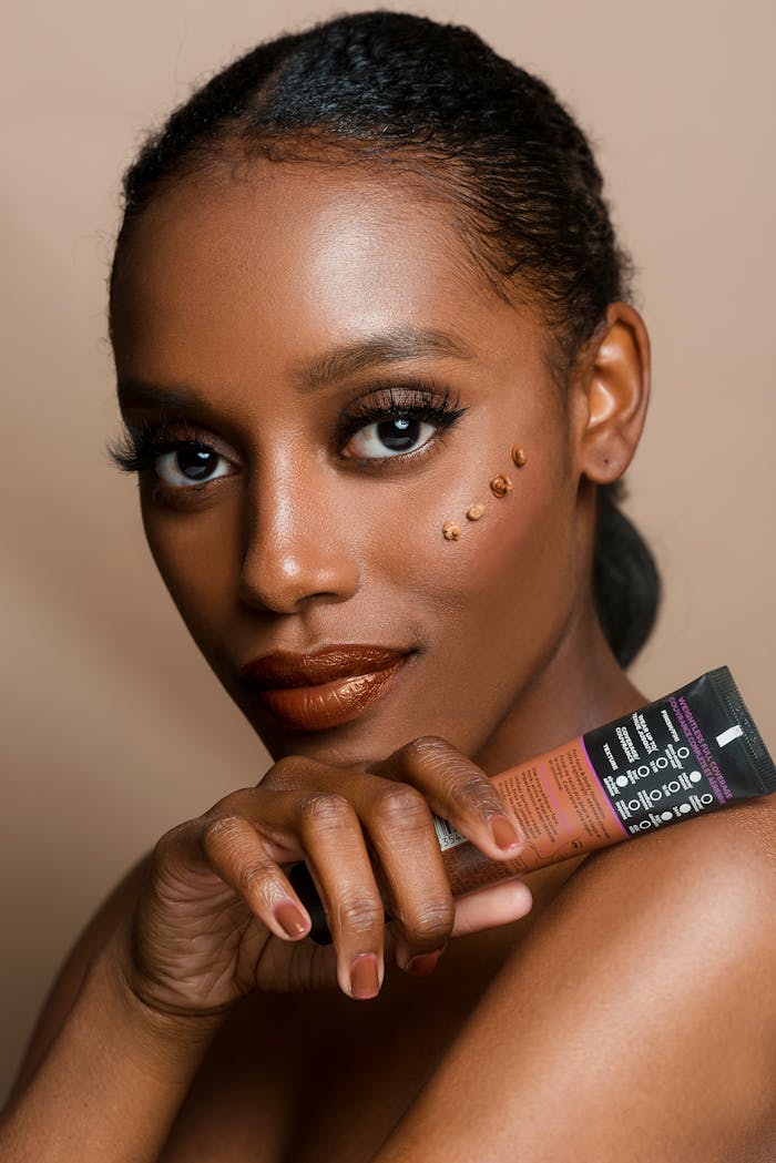 journey Elegant portrait of a woman showcasing skincare product with flawless makeup and glowing skin.